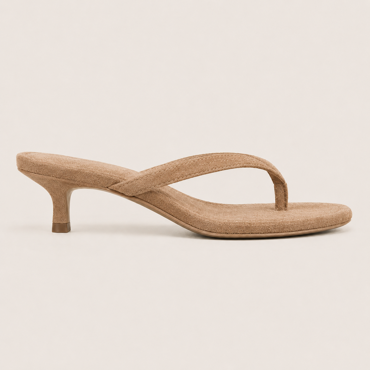 Sandales tongs à talon kitten portées, style minimaliste pour tenue chic d’été.